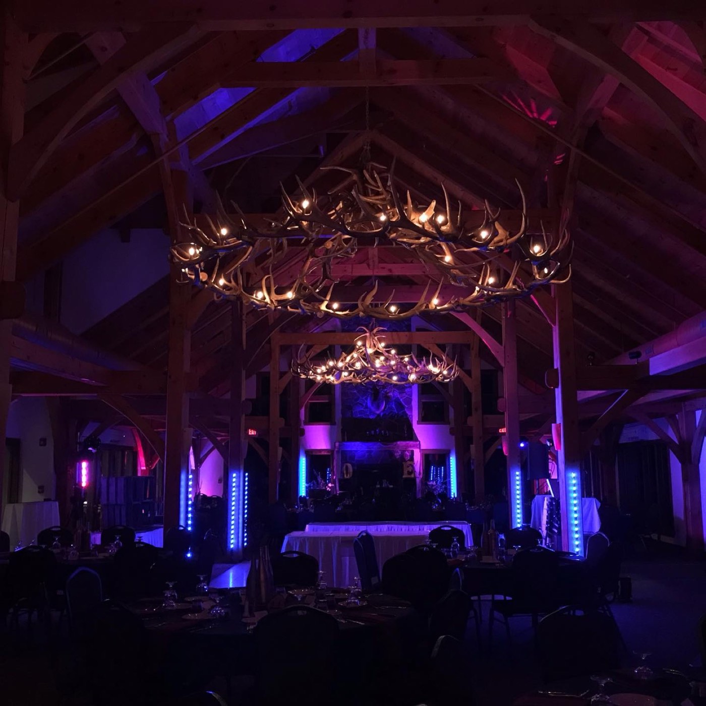 A timber barn reception lit in blue and violet