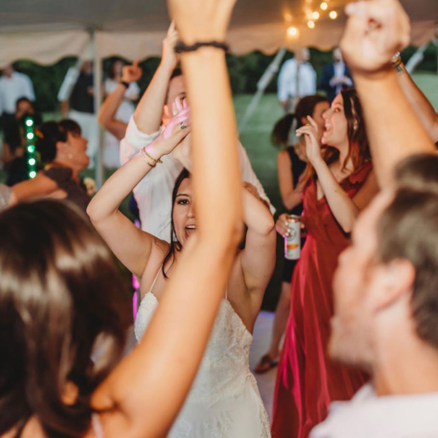Wedding guests with their hands up on the dance floor