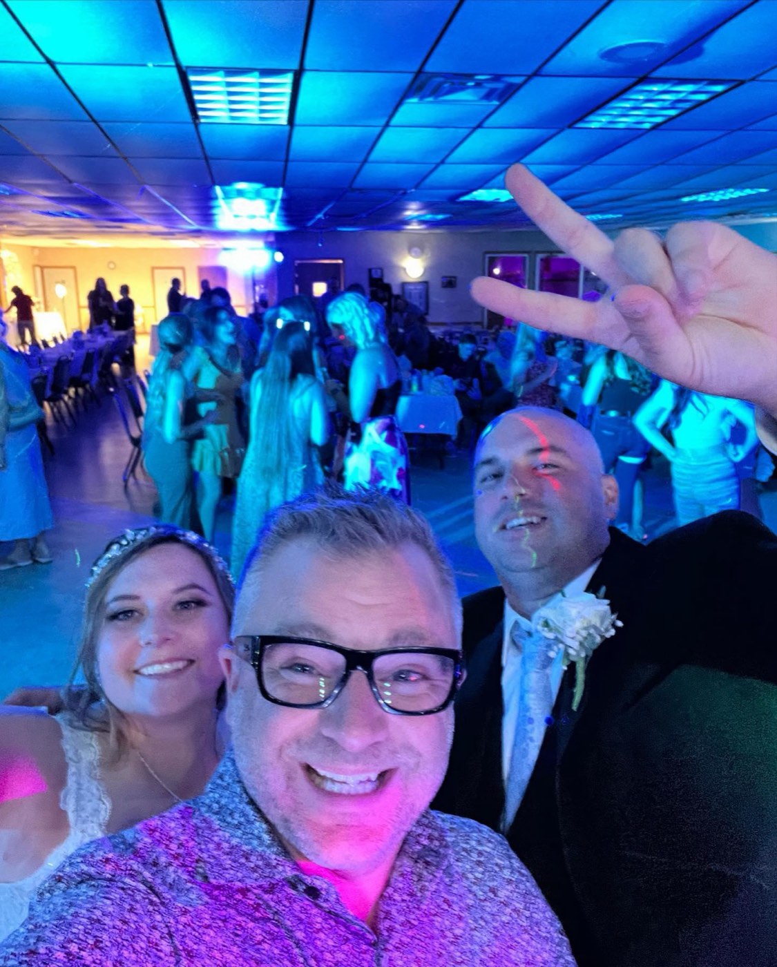 Tim taking a selfie with the couple and a packed floor behind them